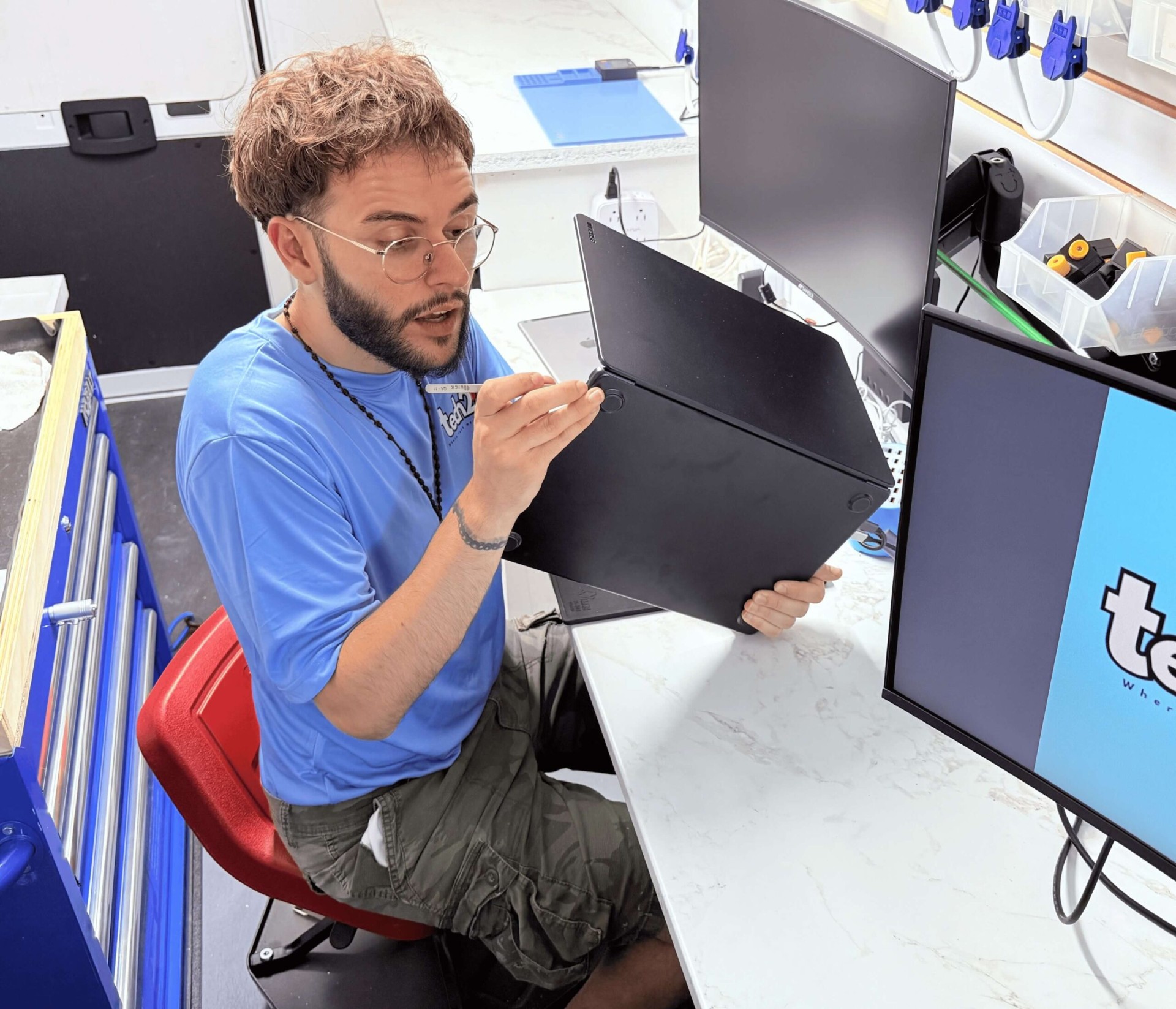 Tech2Go technician working on a computer motherboard at a repair bench